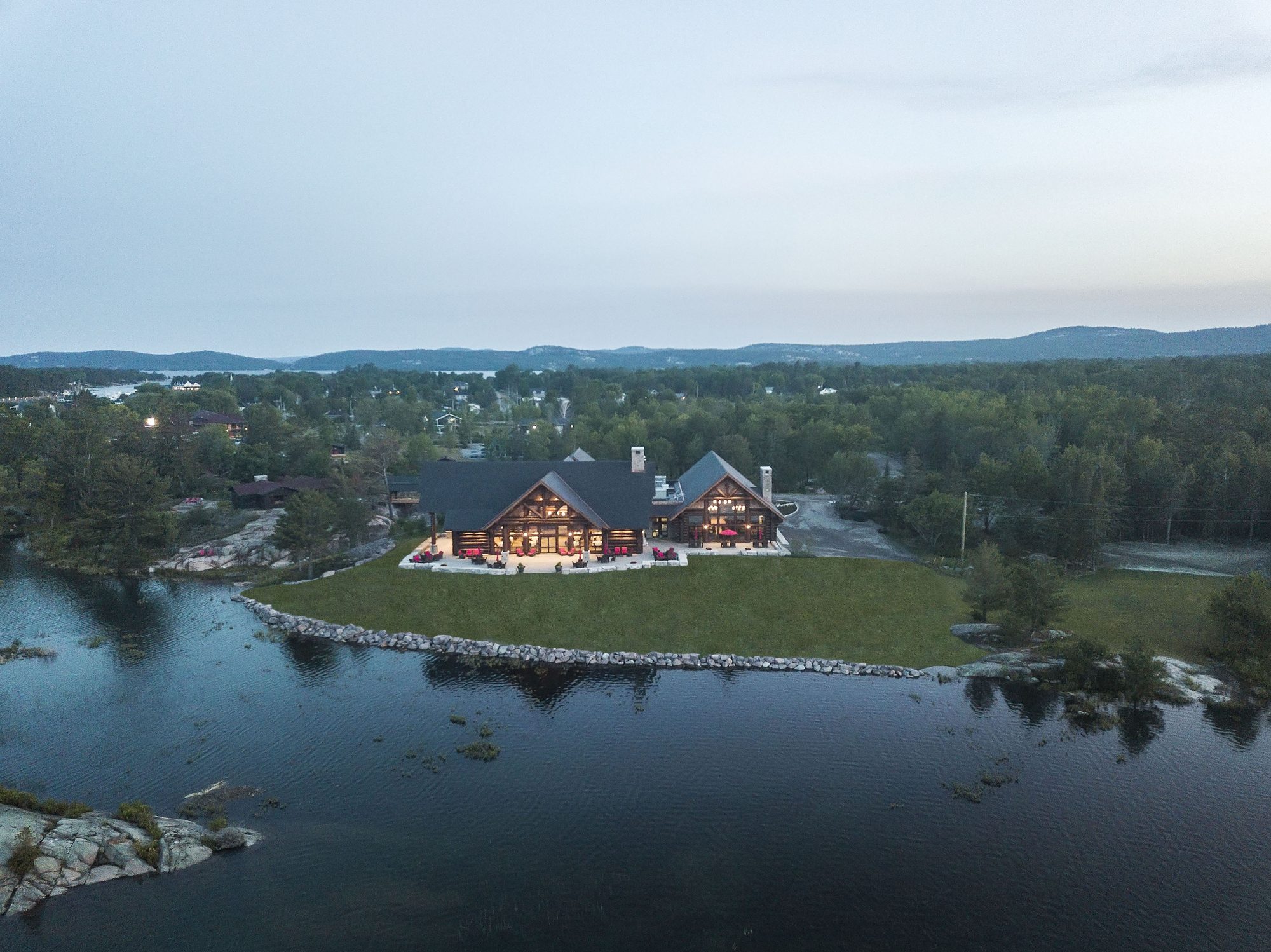 Canada House and the lodge glowing at dusk on the shore of the Killarney Channel