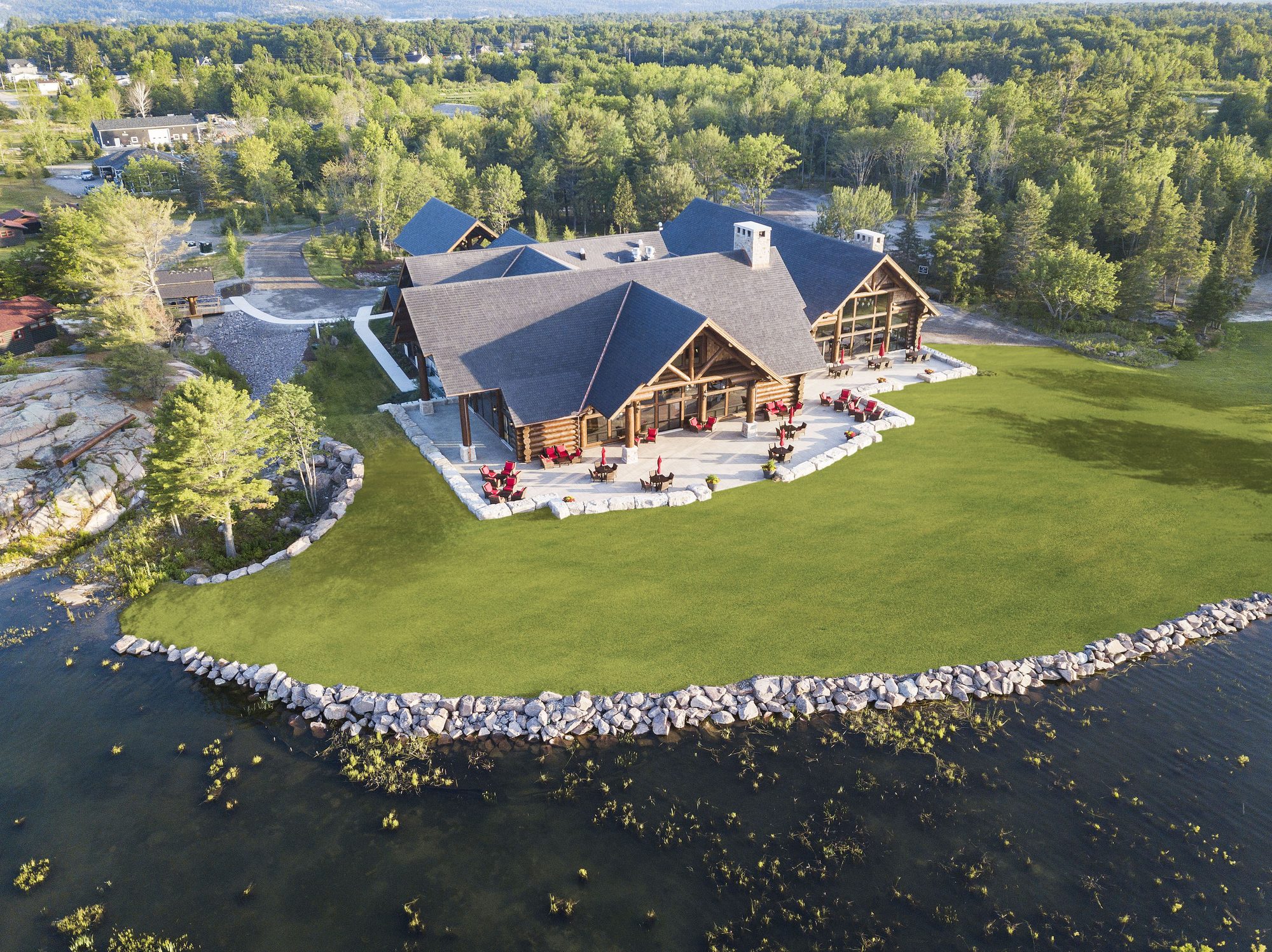 Aerial view of Canada House, its terrace of red chairs and lawn on the Killarney Channel