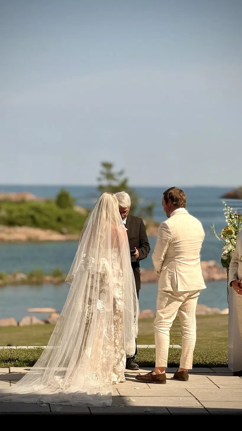 Bride's cathedral veil at a lakeside ceremony