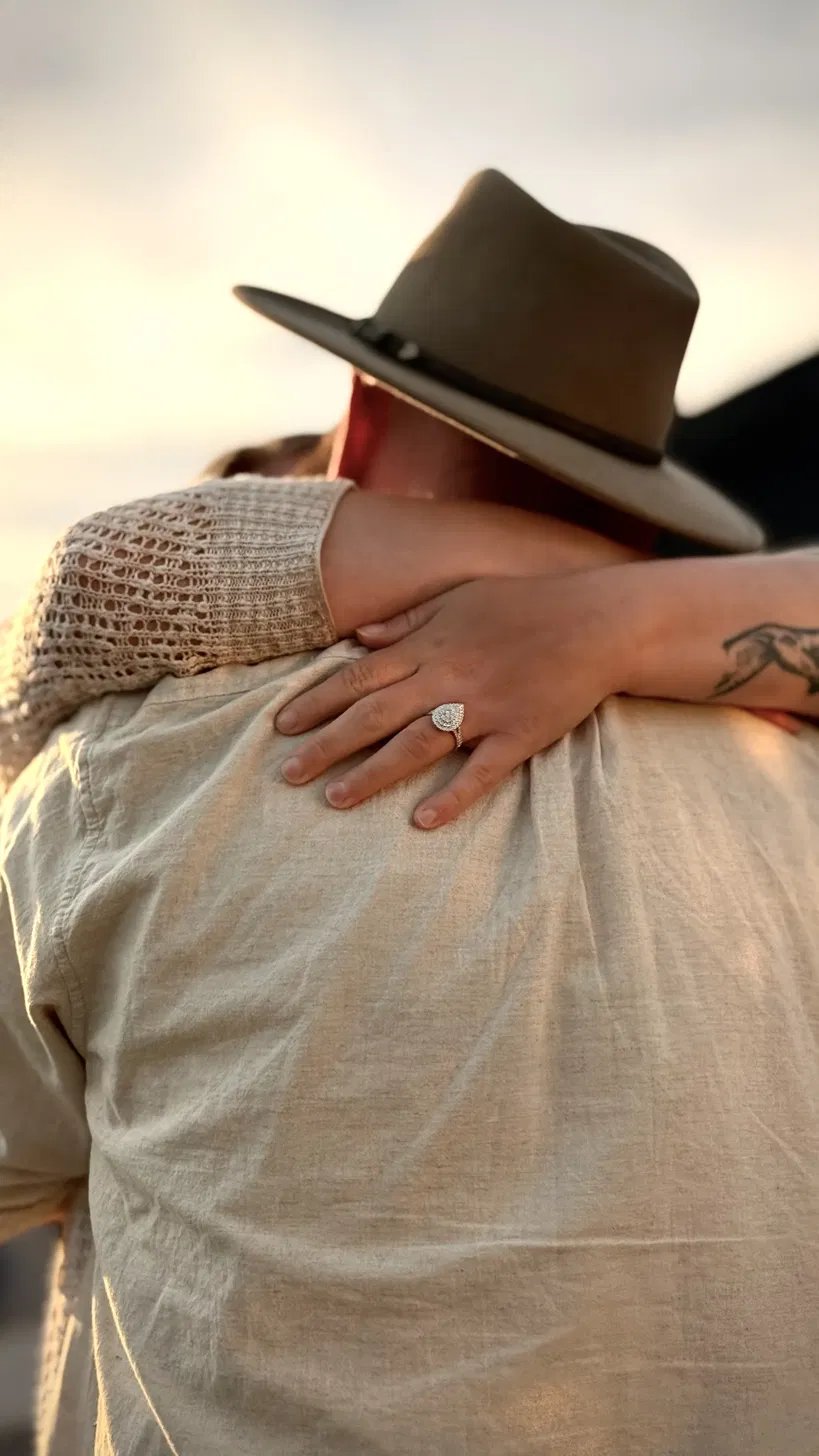 A sunset embrace showing a new engagement ring
