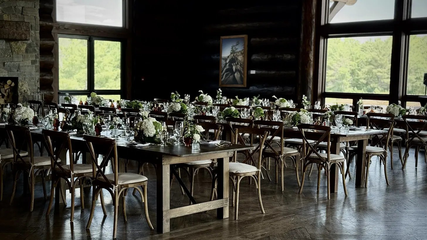 Harvest tables with white hydrangea centrepieces set in Granite Ridge Hall