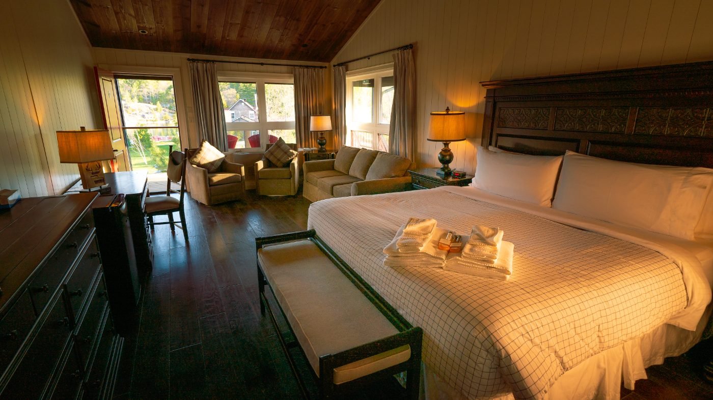 A Covered Portage king suite with a carved headboard, sitting area and channel view