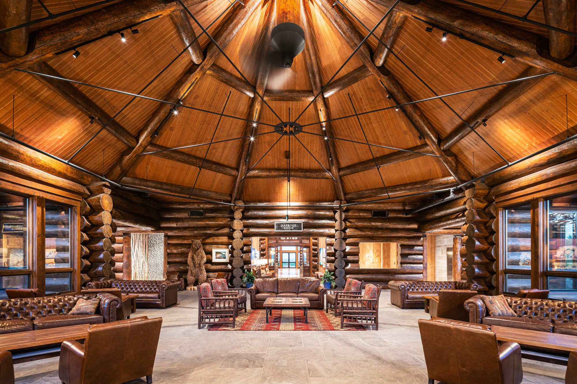The rotunda of Canada House — octagonal log ceiling, leather chesterfields and the Harbour Room beyond
