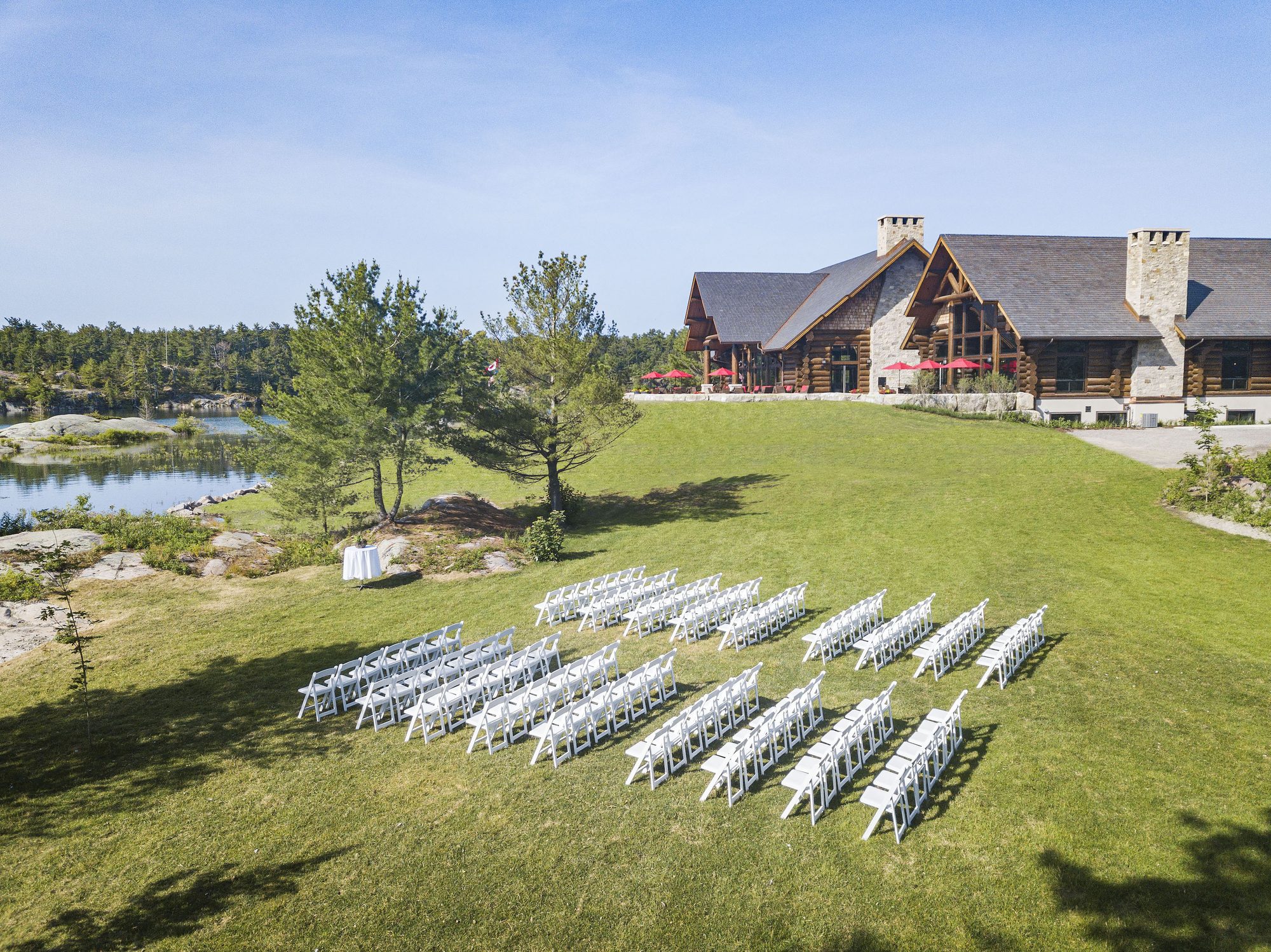 White ceremony chairs set on the Canada House lawn above the water